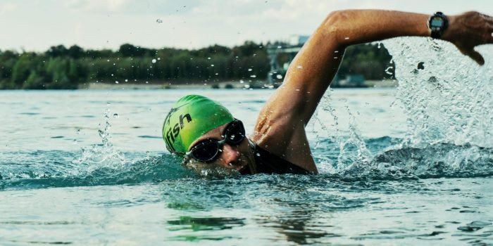 Person swimming laps in a pool, an excellent full-body cardio workout that builds endurance and muscle strength
